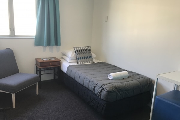 Single room in Nelson Hostel with side table